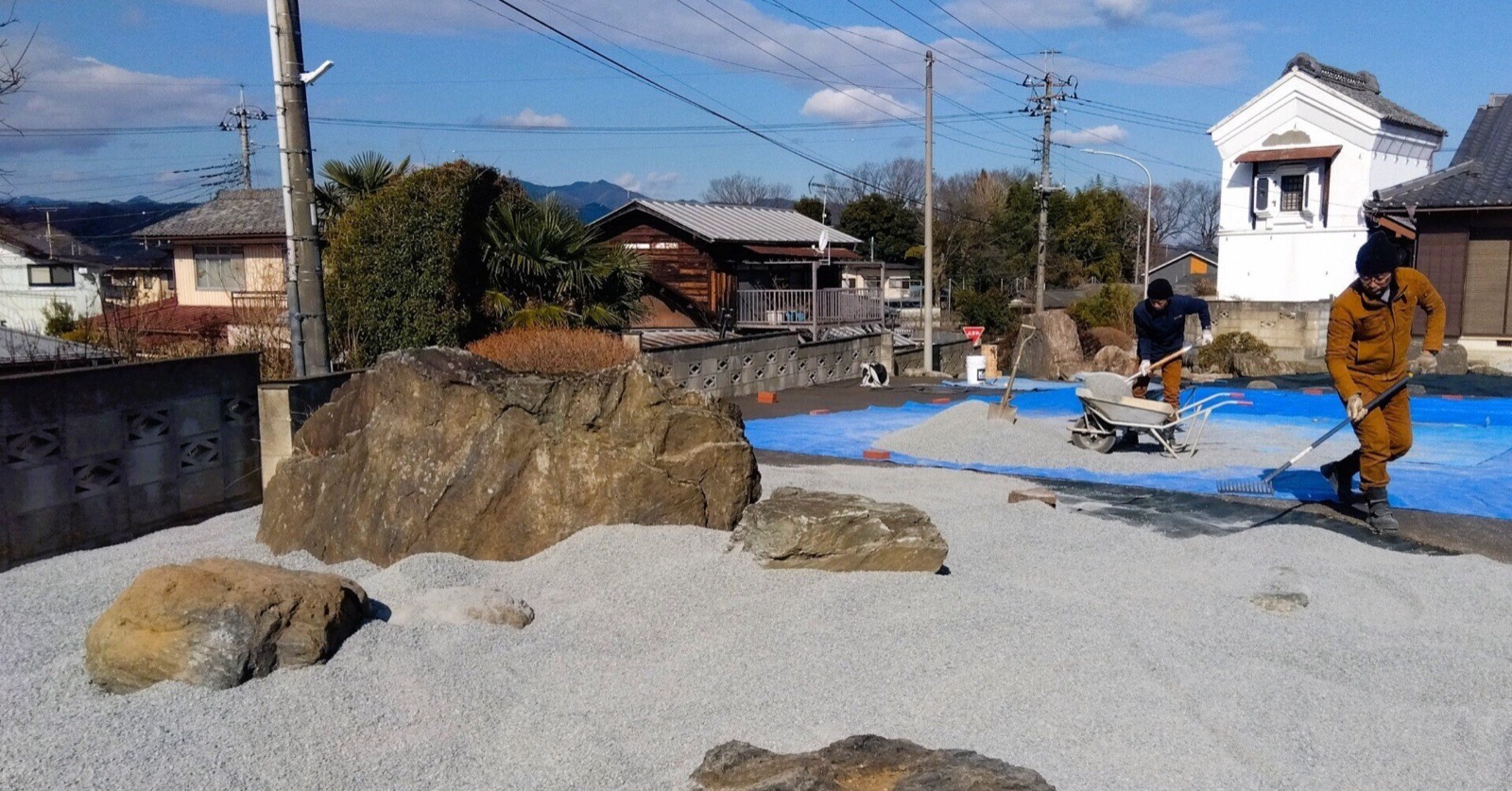 枯山水庭園の施工現場。白砂を敷き、石を据える作業